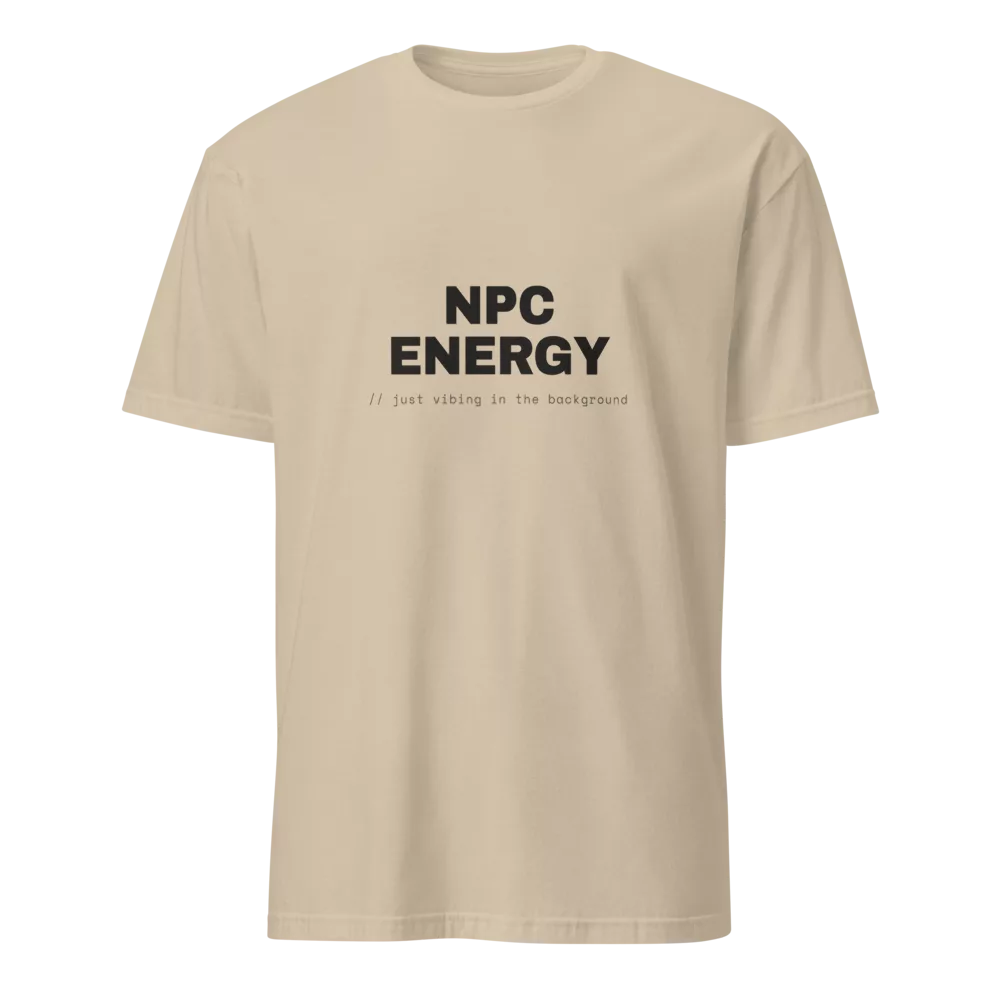 White t-shirt with bold black NPC ENERGY text and a '// just vibing in the background' code caption. - Sand